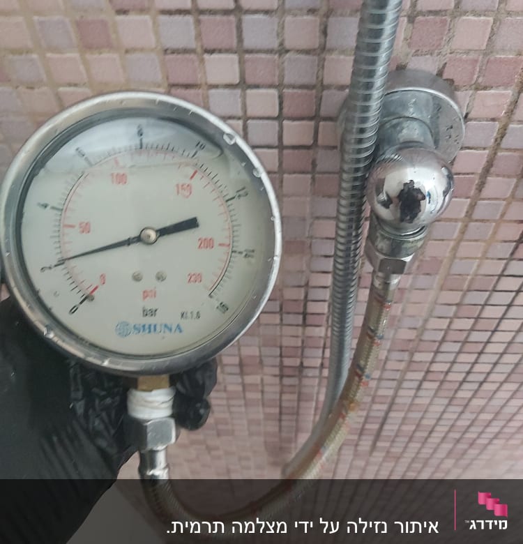 מד לחץ מים מחובר לצינור במקלחת